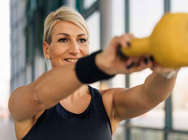 Mujer realizando un entrenamiento con peso en el gimnasio.