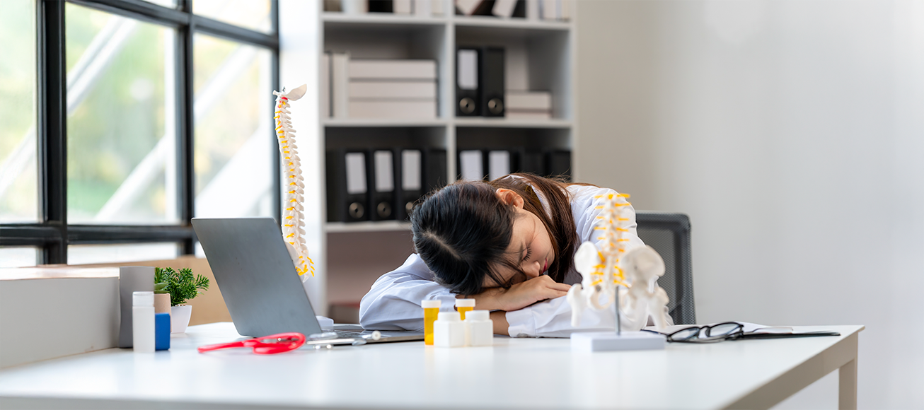 Doctora recostada sobre una mesa