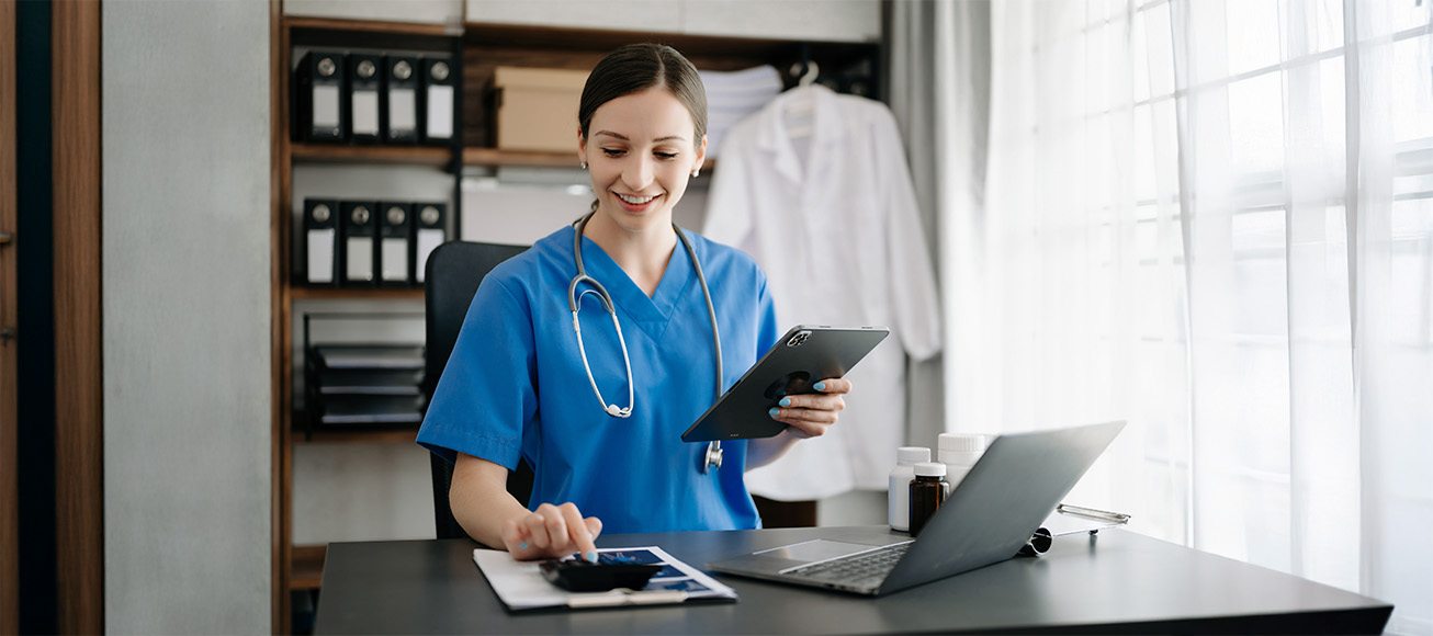 Doctora en su despacho con una calculadora y un ordenador.