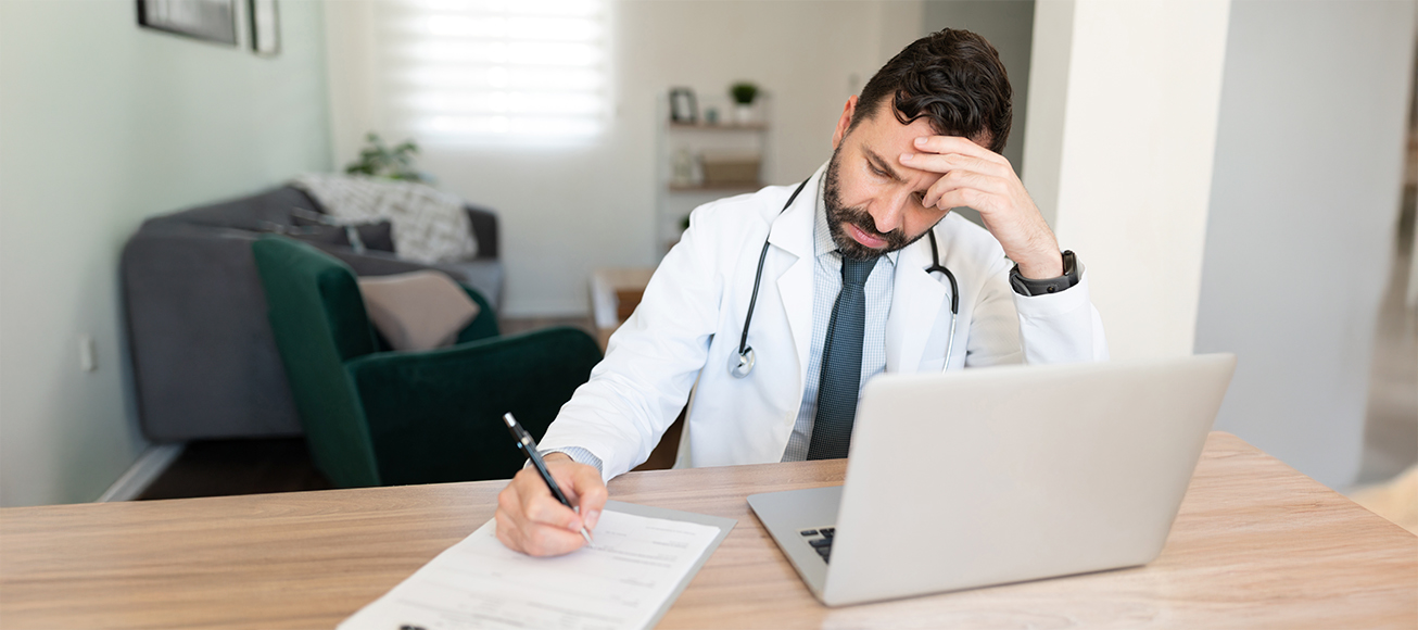 Doctor realizando un informe durante una guardia localizable en su domicilio.