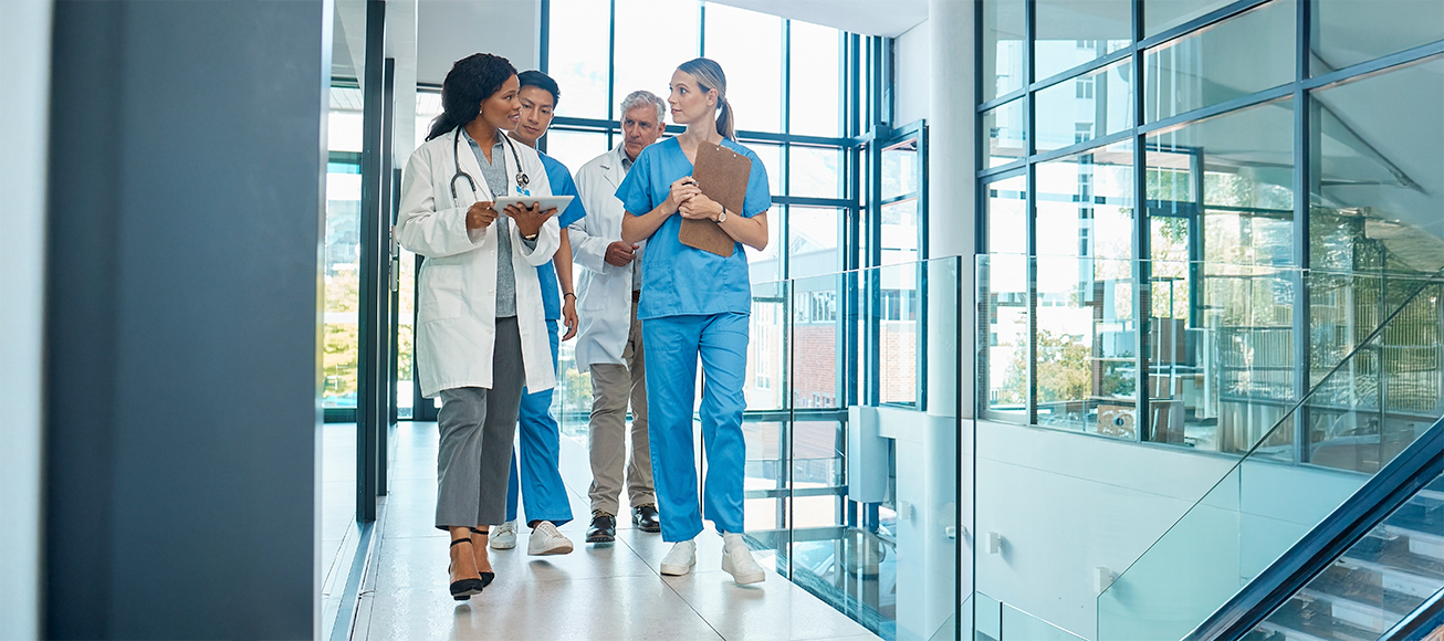 Grupo de médicos recorriendo un pasillo de un hospital.