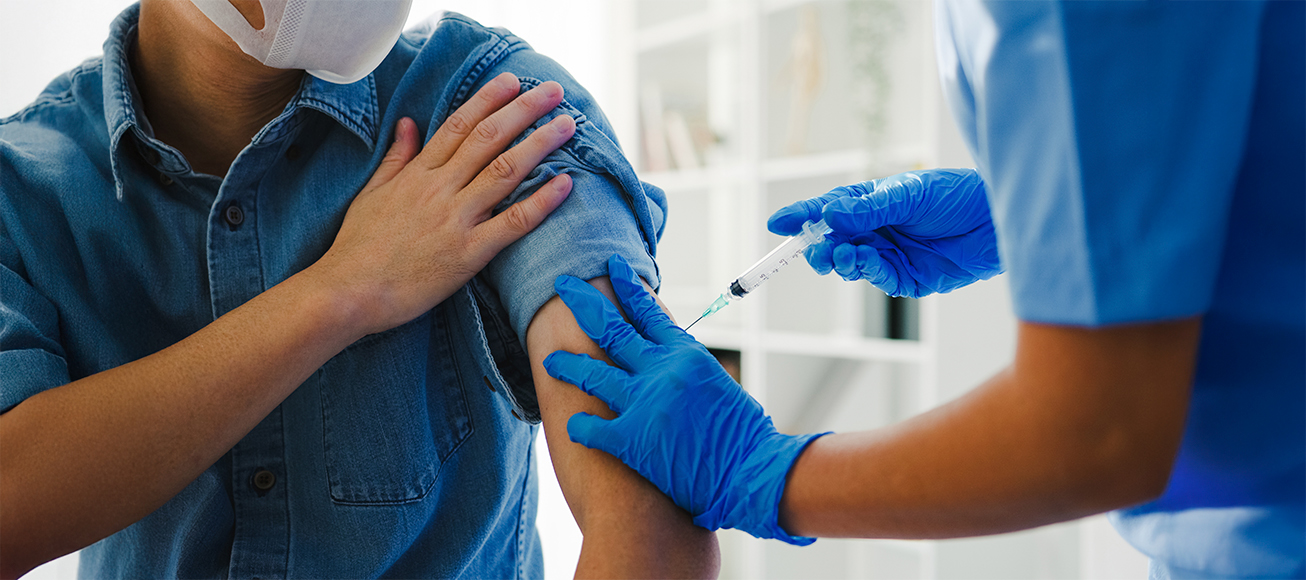 Enfermera inyectando una vacuna a un paciente.