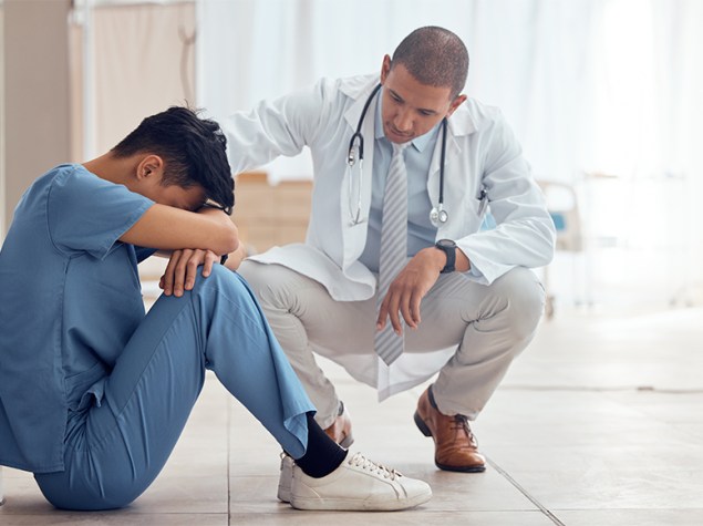 Un médico consolando a un compañero.