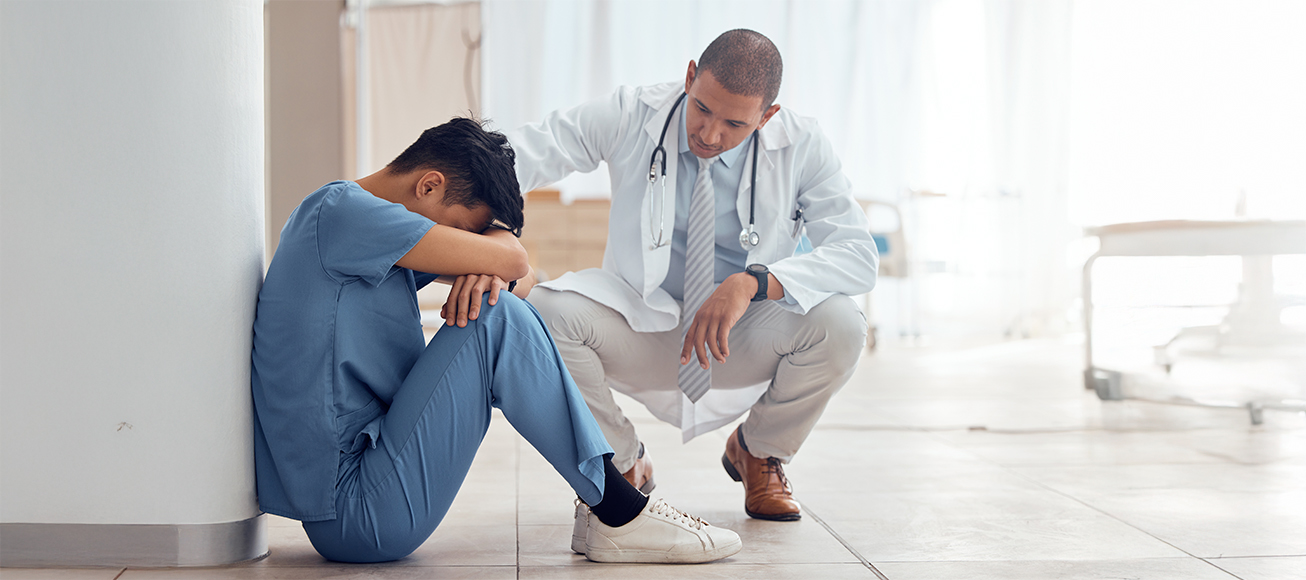 Un médico consolando a un compañero.