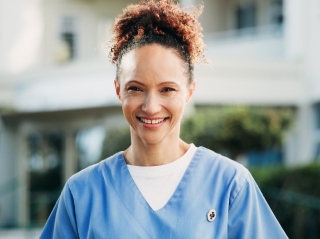 Doctora sonriente a las puertas de un hospital.