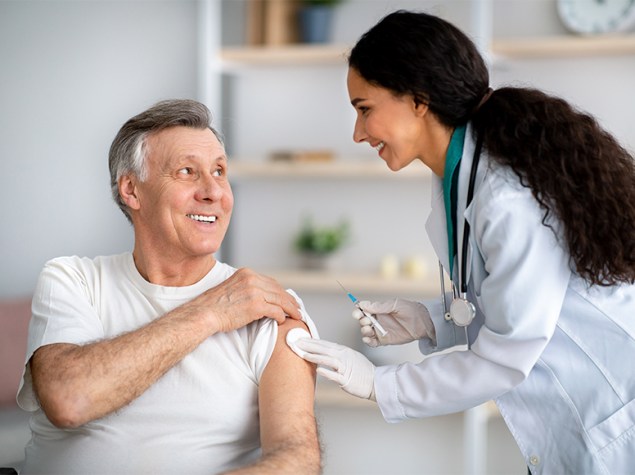 Doctora vacunando a un hombre en un centro de salud.