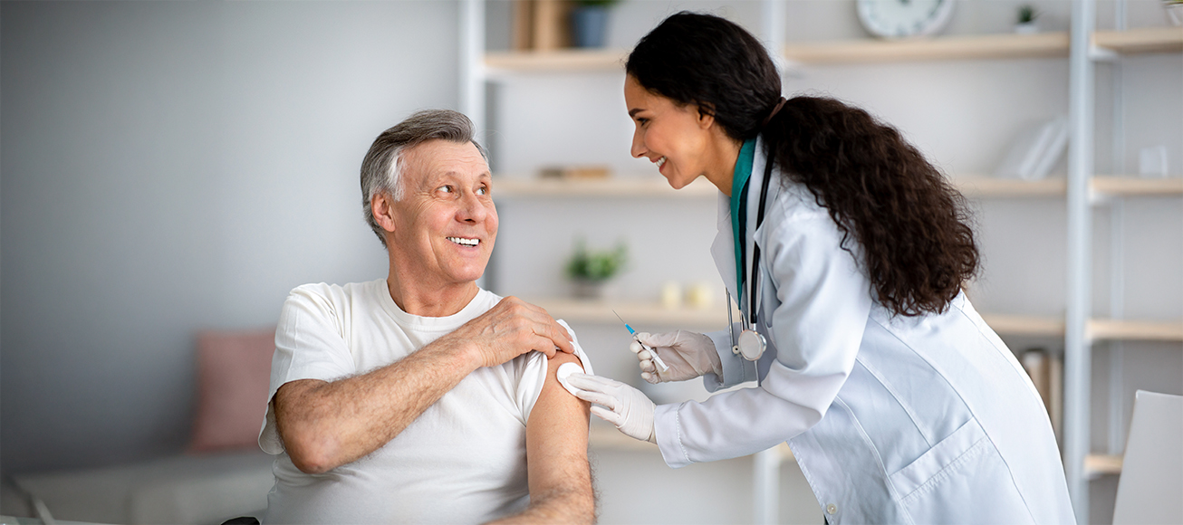 Doctora vacunando a un hombre en un centro de salud.