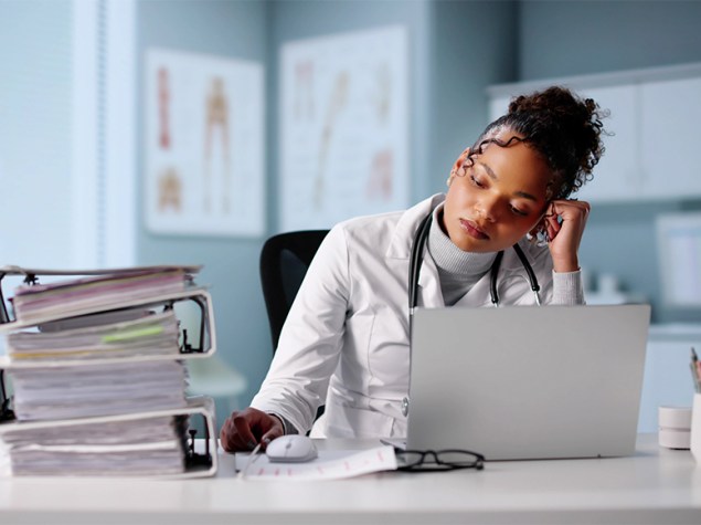 Doctora rellenando papeleo en su consulta.