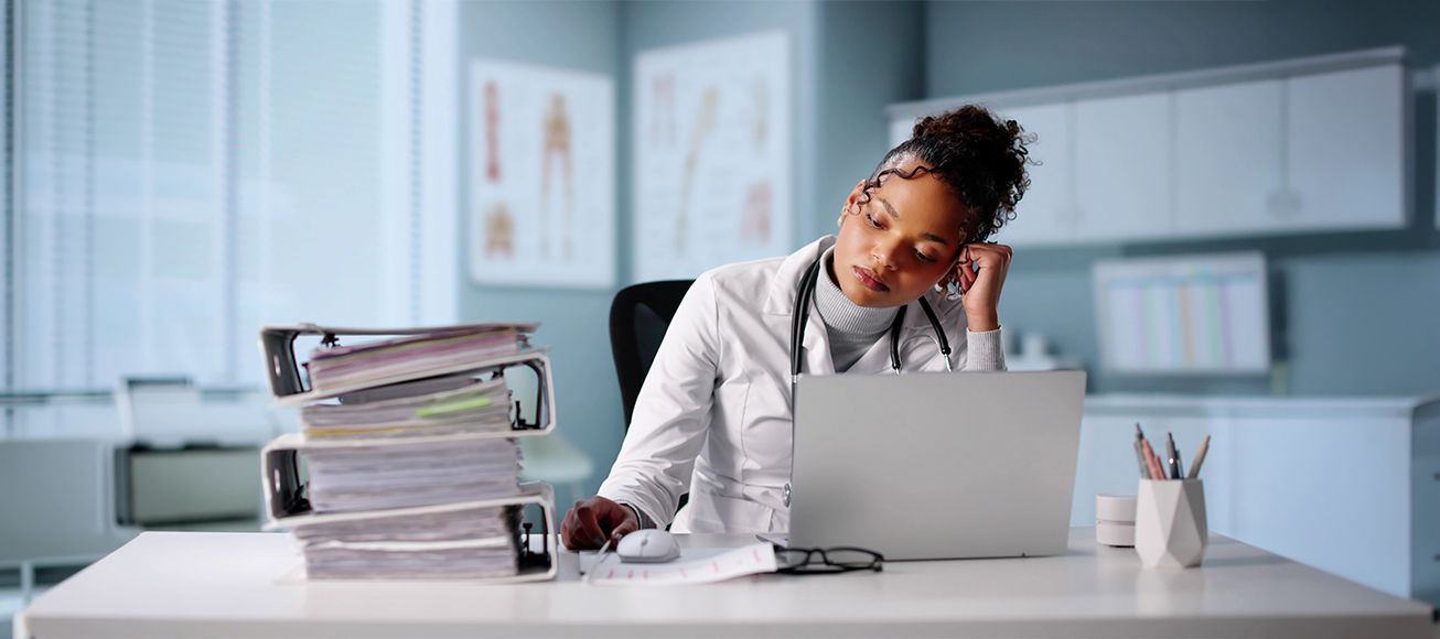 Doctora rellenando papeleo en su consulta.