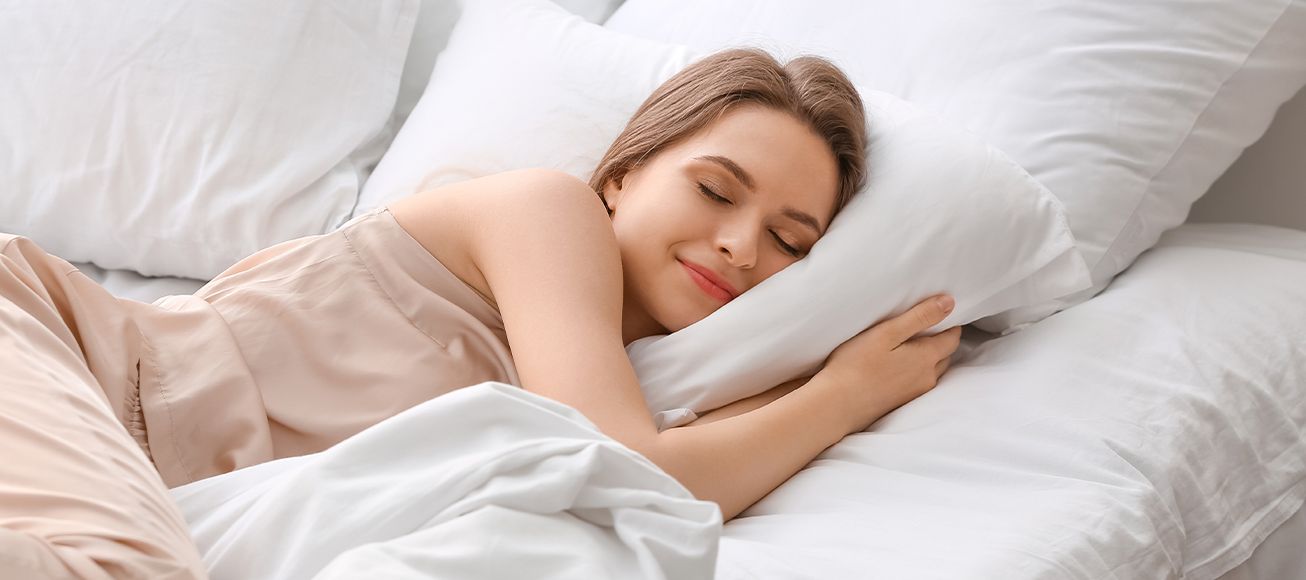 Una chica duerme en su cama.