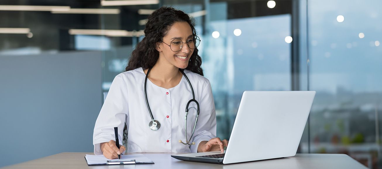 Doctora realizando una consulta en su ordenador.