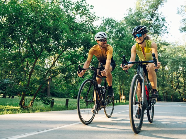 Dos personas haciendo deporte en bicicleta.