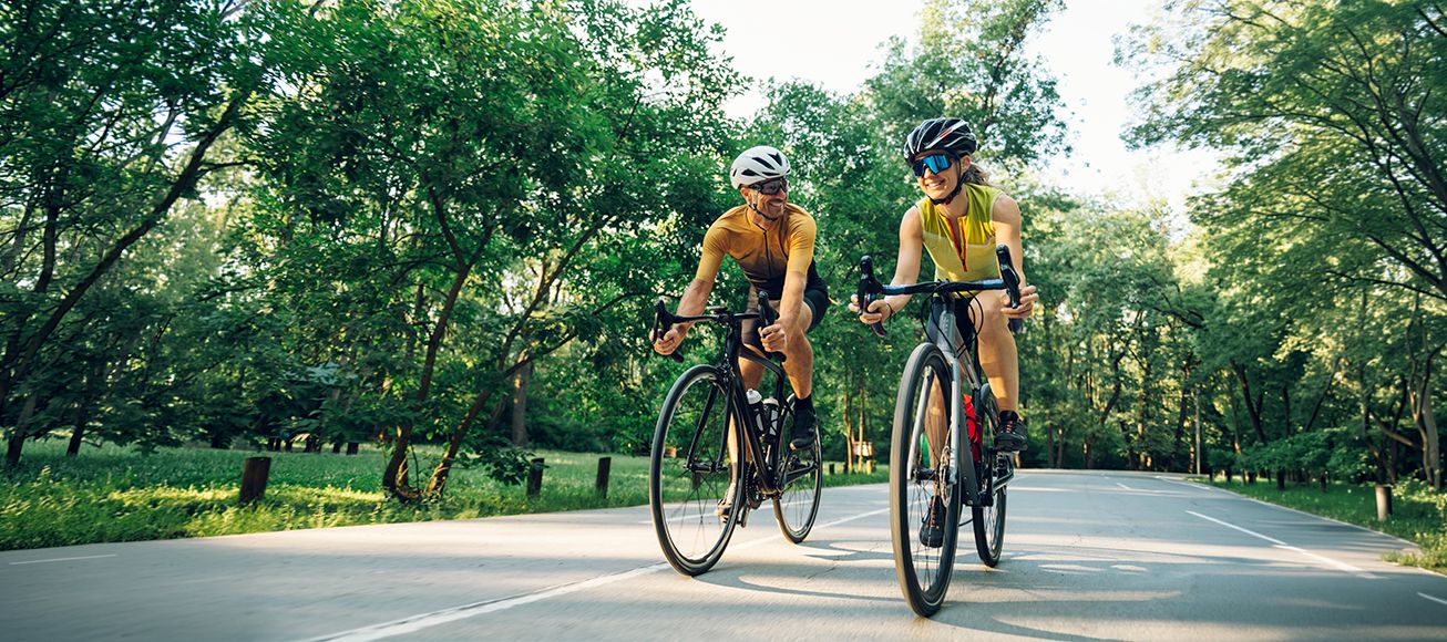 Dos personas haciendo deporte en bicicleta.