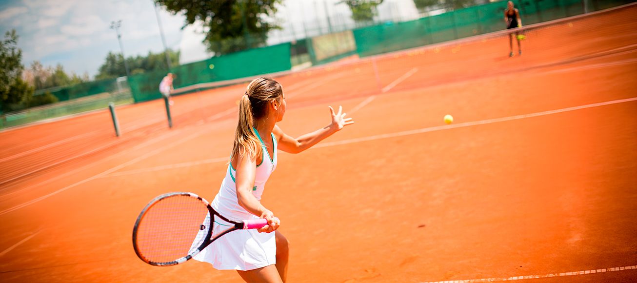 Una chica jugando al tenis.