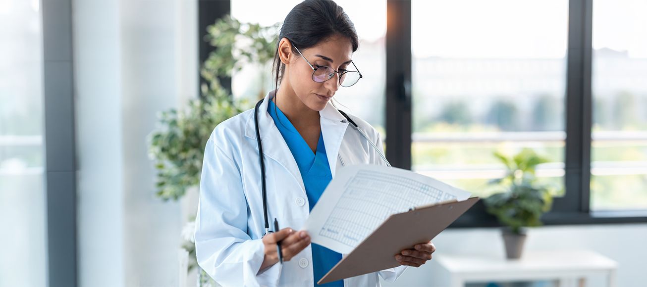 Doctora examamina unos papeles en un hospital.