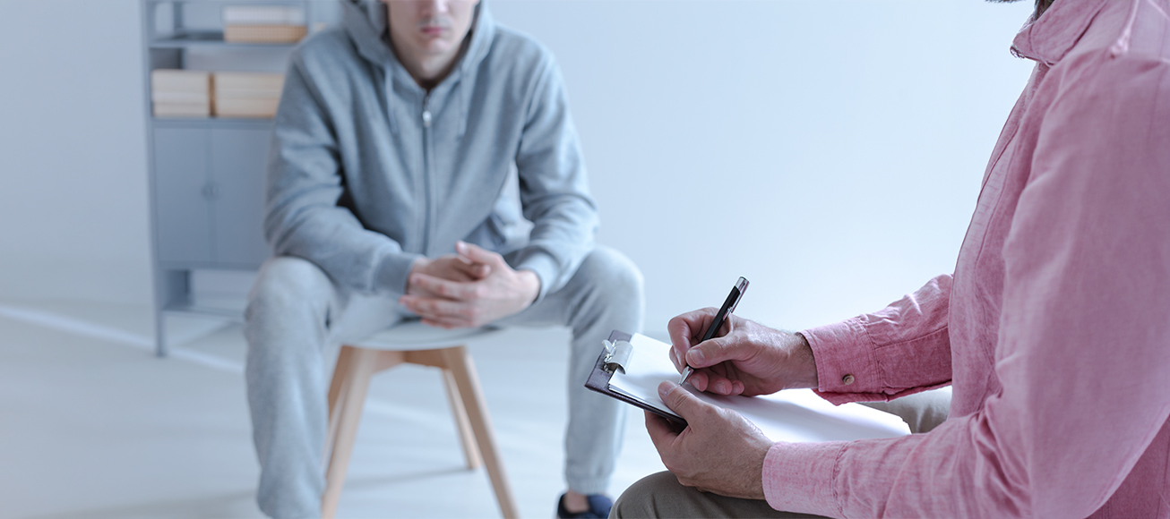 Doctor en salud mental atiende a un recluso en una sala común de la cárcel.